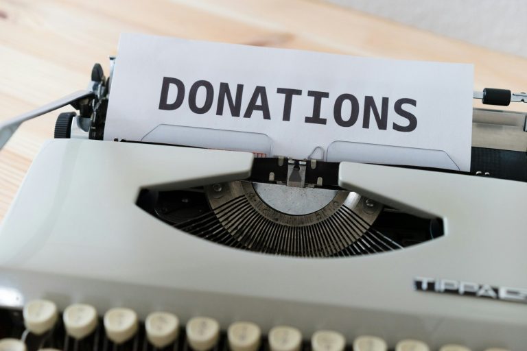 A sheet of paper in a typewriter reading “Donations”.